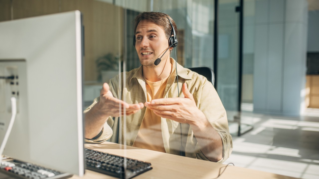 Man with headset using his hands to explain benefits