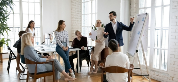 Group of employees of all ages working in a conference room together.