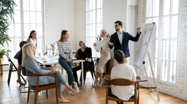 Group of employees of all ages working in a conference room together.