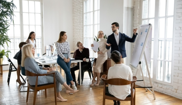 Group of employees of all ages working in a conference room together.